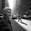 Elderly Woman in Busy City Street Surrounded by Vintage Cars