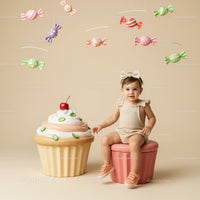 Toddler Sitting Next to Giant Cupcake with Candy Mobile