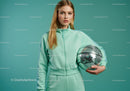 Young Woman in Mint Green Tracksuit Holding Disco Ball in Studio