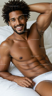 Smiling man relaxing on bed in white underwear