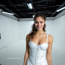 Smiling Young Woman in White Satin Dress in Modern Studio