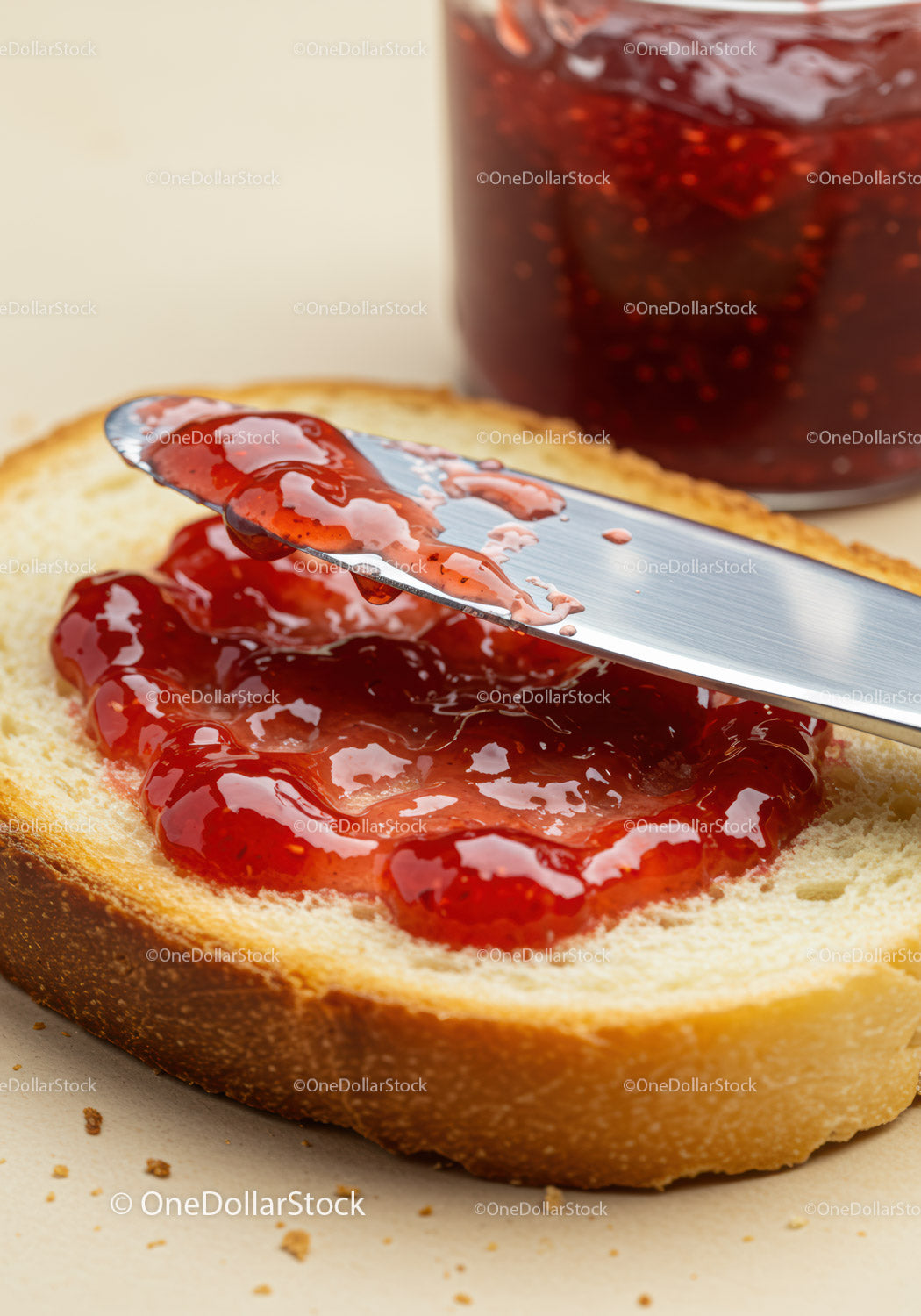 Spreading Fresh Strawberry Jam on Soft White Bread