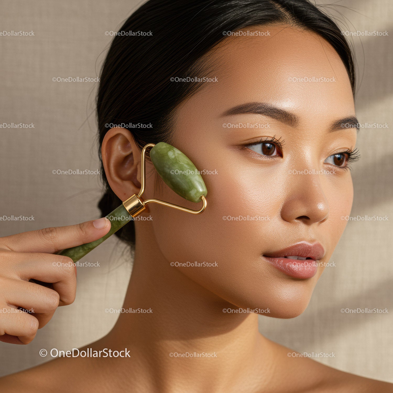 Asian Woman Using Jade Roller for Skin Facial Massage