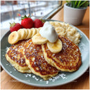 Golden Brown Pancakes with Fresh Fruit Banana Strawberries and Whipped Cream