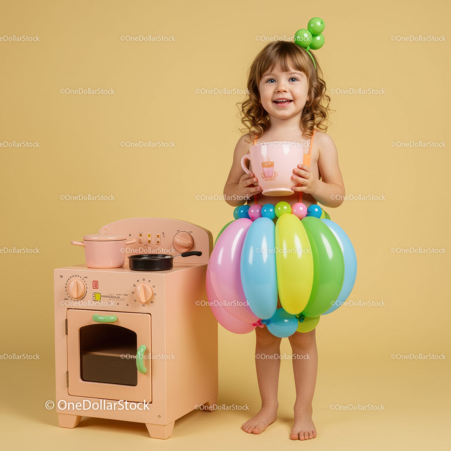 Happy toddler playing with colorful balloons and toy kitchen