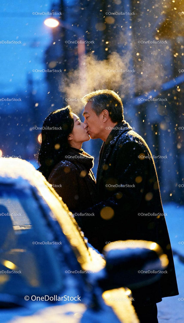 Couple sharing a romantic kiss on snowy winter evening