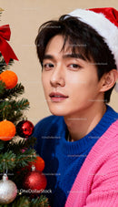 Young man in Santa hat decorating Christmas tree