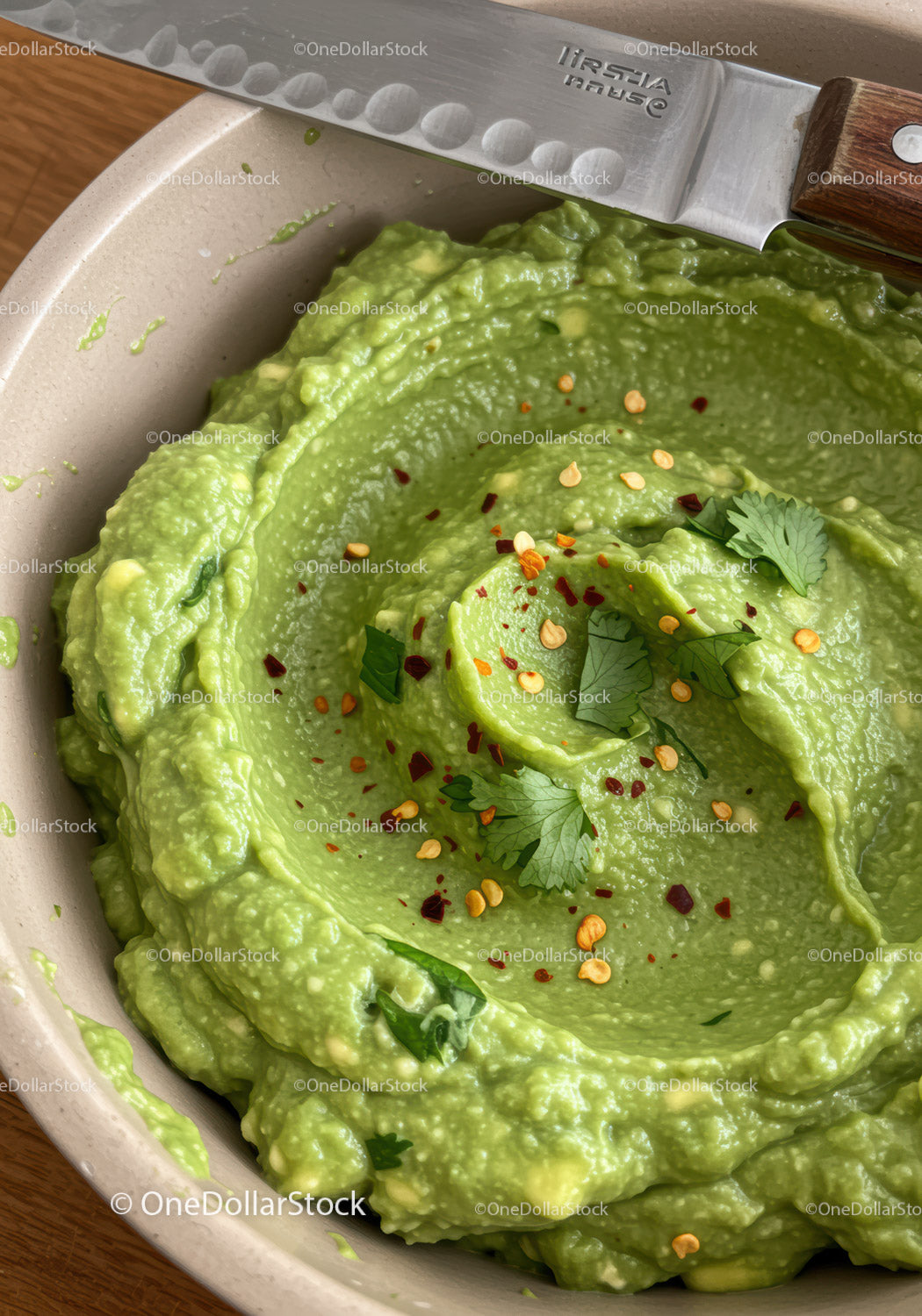 Fresh creamy guacamole garnished with herbs and spices