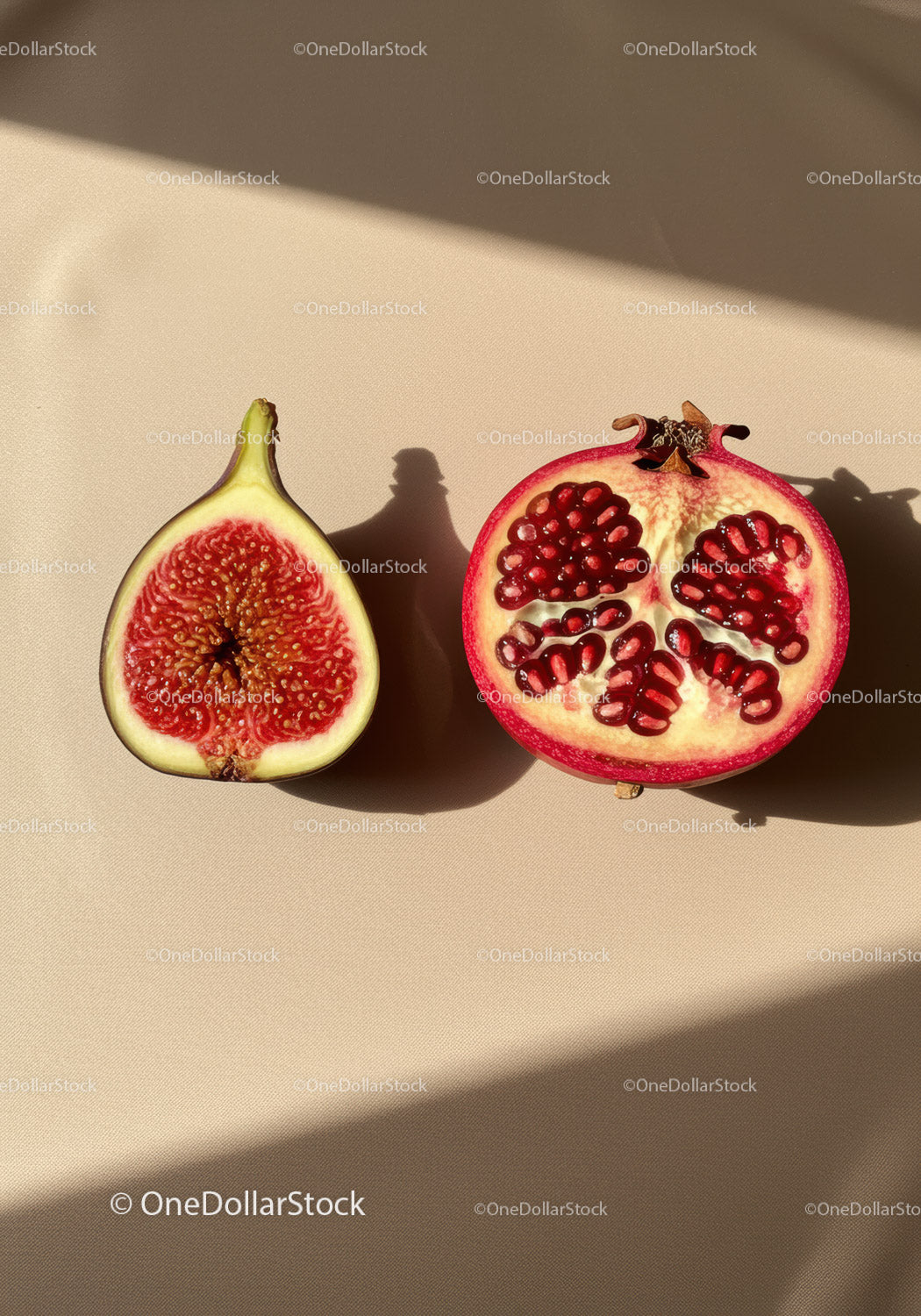 Fresh cut fig and pomegranate on beige background