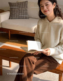 Young woman enjoying a book in warm cozy interior