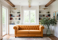 Bright living room with orange tufted sofa and bookshelves