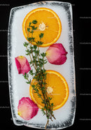 Orange slices and herbs frozen in clear ice block