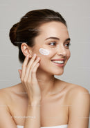 Young Woman Applying Moisturizer Showing Clear Skin and Bright Smile