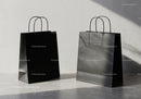 Minimalistic black shopping bags on concrete floor
