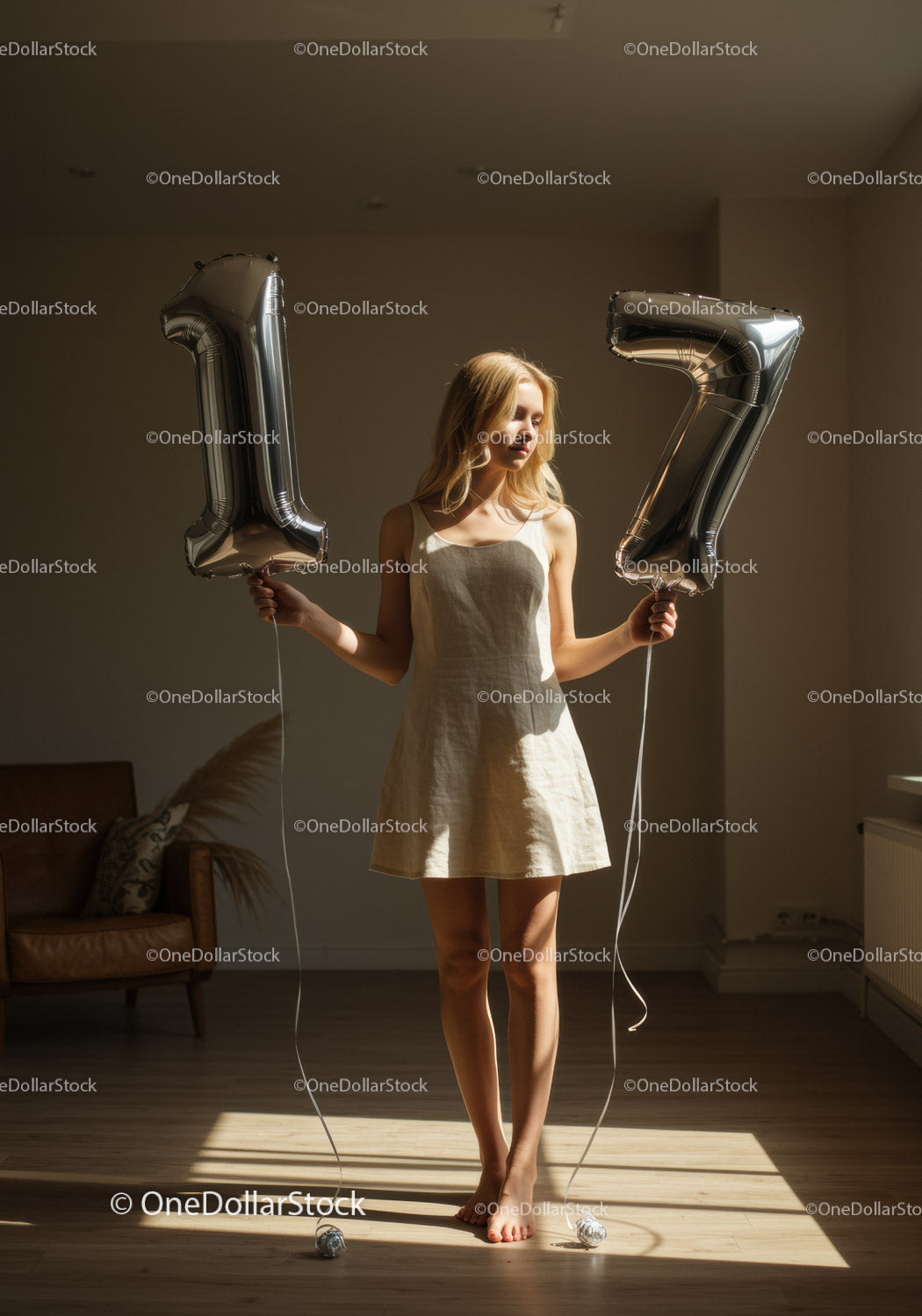 Young woman holding number balloons in sunlit room