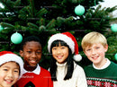 Smiling Kids in Santa Hats by Christmas Tree