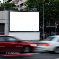 Urban street with blank billboard and moving cars