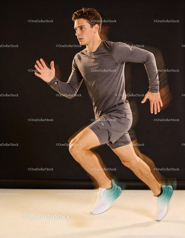 Focused young male sprinter training indoors in motion