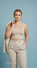 Stylish Young Woman in Beige Crop Top and Elegant Trousers on Studio Background