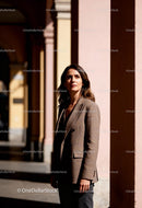 Thoughtful woman standing in sunlit urban colonnade