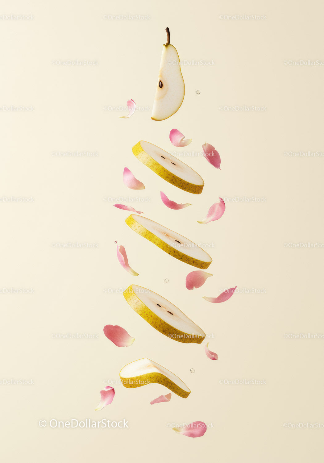 Sliced pear with floating pink petals on light background