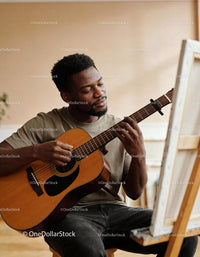 Young man playing acoustic guitar with peaceful focus