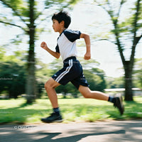 Young Boy Running Energetically in Sunny Park