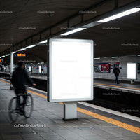 Empty lightbox on urban subway platform with cyclist