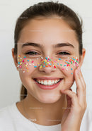 Young Woman Smiling with Colorful Sprinkles on Face in Bright Portrait
