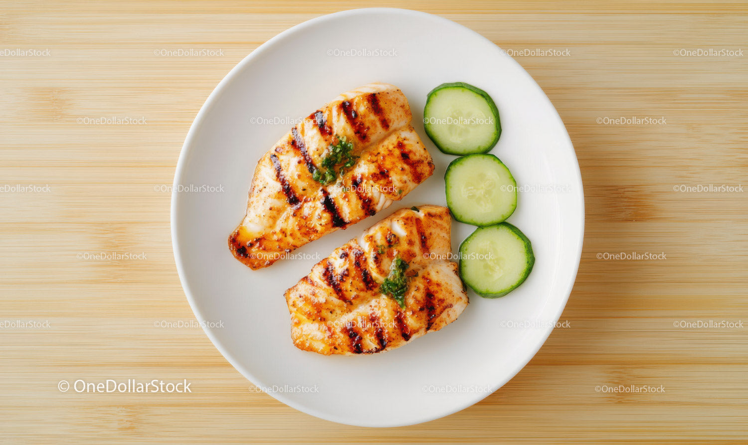 Grilled Fish Fillets with Cucumber Slices on White Plate