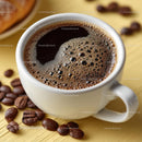 Delicious Coffee in a White Cup with Roasted Beans on Wooden Plate