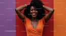 Joyful Woman with Curly Hair Smiling Against Colorful Wall