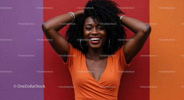Joyful Woman with Curly Hair Smiling Against Colorful Wall