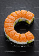 Fresh salmon sushi ring with avocado on black plate