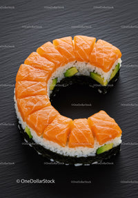 Fresh salmon sushi ring with avocado on black plate