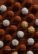 Assorted chocolate truffles with coconut and nuts on cocoa