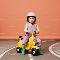 Toddler riding yellow toy scooter with safety helmet