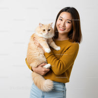 Smiling young woman holding fluffy cream cat