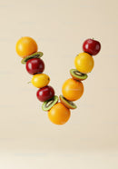 Colorful fresh fruits arranged in V shape on beige