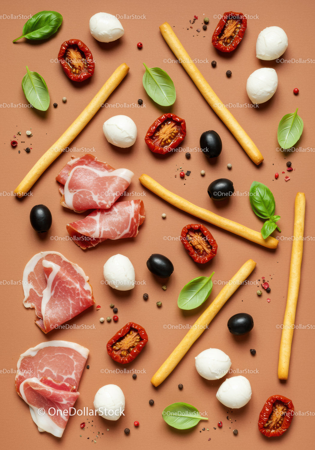 Italian antipasto ingredients arranged on brown background