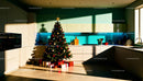 Modern kitchen with decorated Christmas tree and gifts