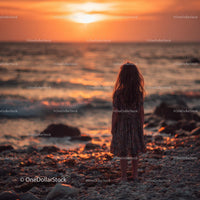 Silhouette of a Child at Sunset by the Ocean Shore