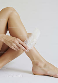 Feminine Grace in a Minimalist Setting with Feather and Human Skin