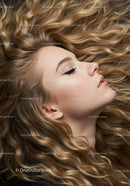 Young woman with long curly golden hair lying down