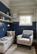 Cozy Nursery Room with Beige Armchair and Navy Blue Wall Paneling