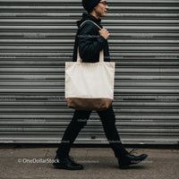 Young man walking with canvas tote bag urban style