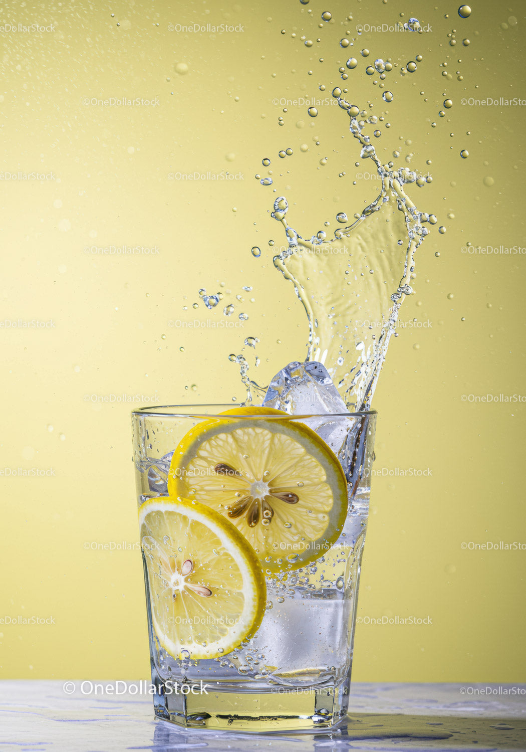 Fresh Lemon Slices Splashing Into Glass of Water