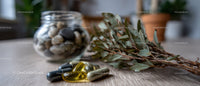 Eucalyptus and Herb Sprig with Assorted Herbal Supplements on Wooden Surface