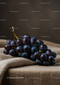 Fresh dark grapes resting on textured fabric surface
