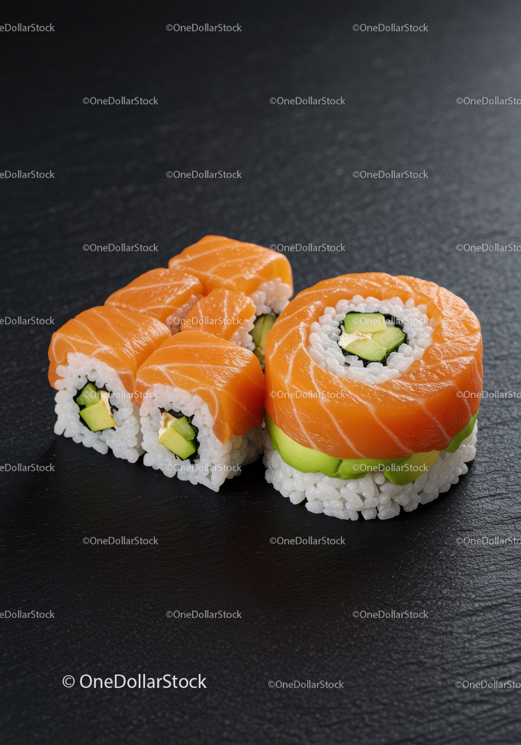 Fresh salmon sushi rolls with avocado on black plate